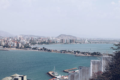 View of city at waterfront against sky