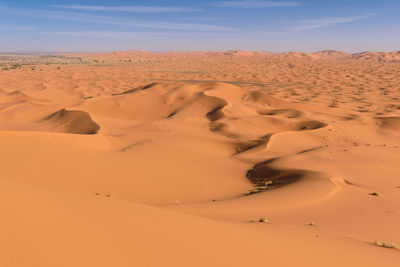 Sand dunes in desert against sky