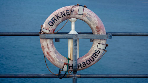 Close-up of lifebelt hanging on railing of boat