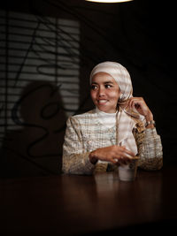 Portrait of woman sitting on table