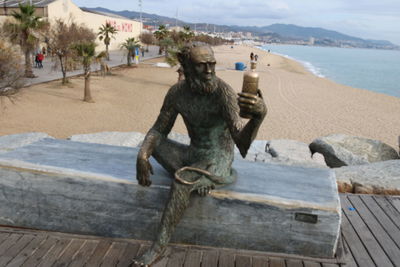 Monkey statue by sea against sky