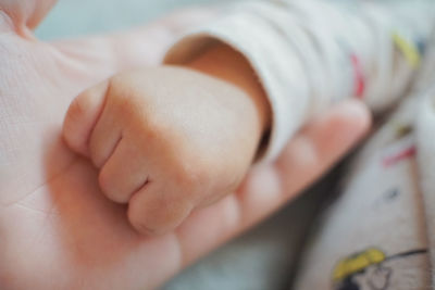 Close-up of baby hand on bed