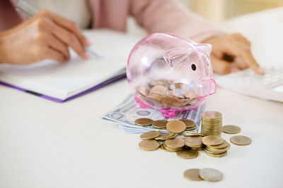 Midsection of business person counting money in office