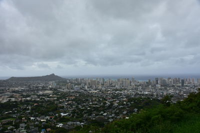 Aerial view of buildings in city against sky