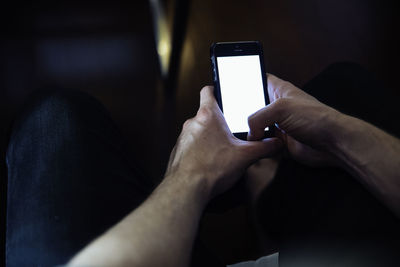 Midsection of man using mobile phone