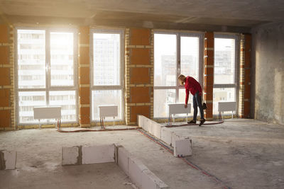 Side view of woman working in building