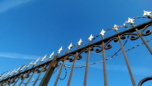 Low angle view of metal against blue sky