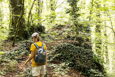 Full length of woman standing in forest