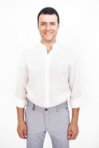 Portrait of smiling man standing against white background