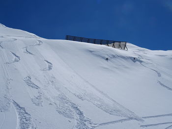 Snow covered mountain against clear blue sky