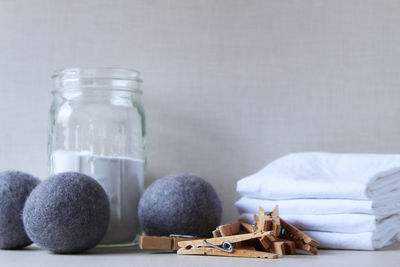 Close-up of clothespin and textiles on table against wall