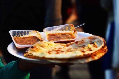 Cropped hand holding food in plate