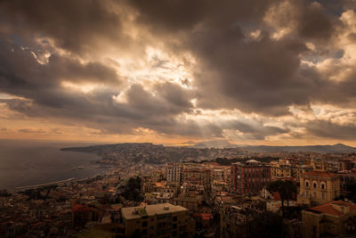 High angle view of cityscape against cloudy sky during sunset