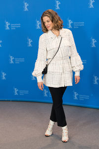 Portrait of young woman standing against blue wall