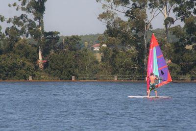 Scenic view of flag on lake against trees