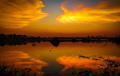 Scenic view of lake against orange sky