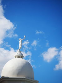 Low angle view of statue against blue sky