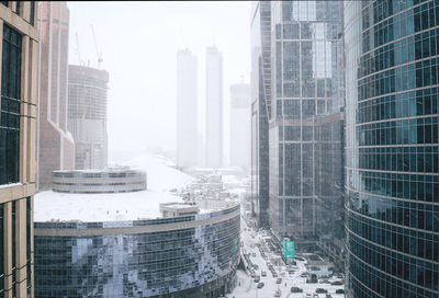Buildings in city during winter blizzard