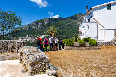 Group of people outside building against mountain range