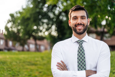 Portrait of smiling young man in formalwear standing at park