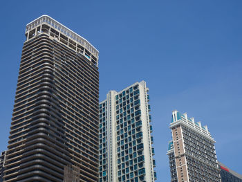 Low angle view of modern buildings against clear blue sky