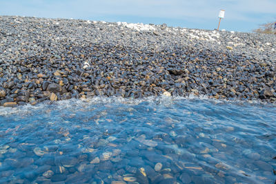 Pebbles on beach against sky