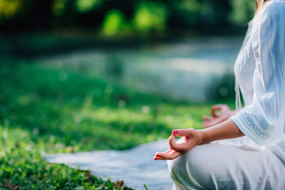 Meditation by the water, lotus position, green background