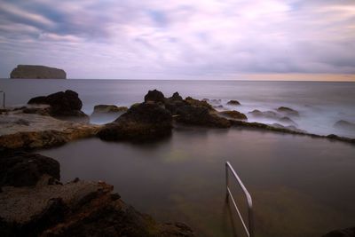 Rocks on sea shore against sky