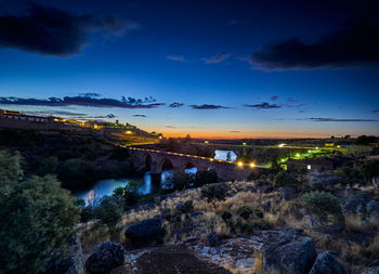 Illuminated city against sky at night