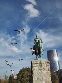 Low angle view of birds flying against sky