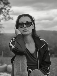 Portrait of young woman wearing sunglasses against sky