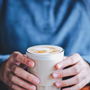Close-up of hand holding coffee cup