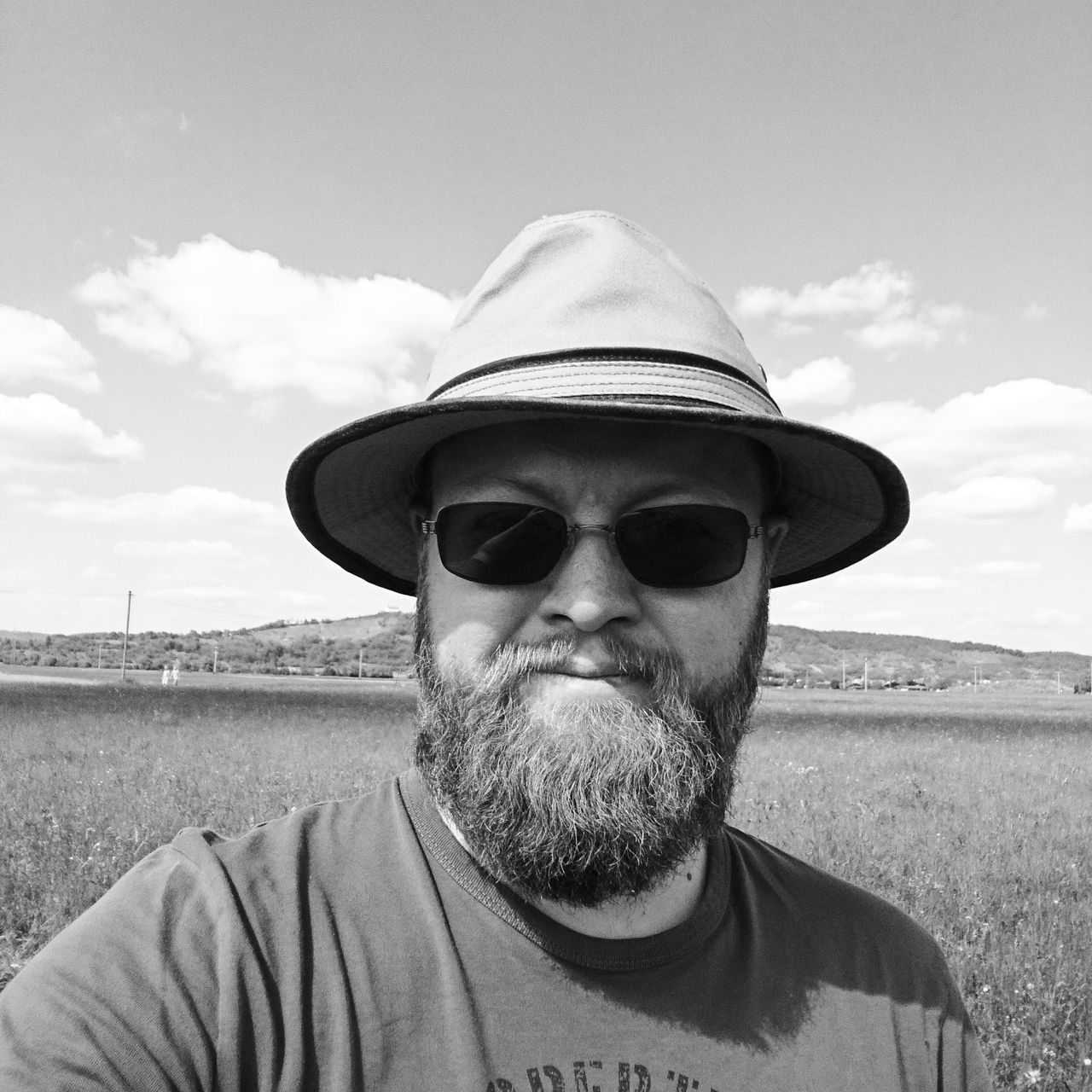 beard, real people, portrait, one person, front view, looking at camera, sky, field, outdoors, headshot, day, cap, lifestyles, nature, close-up, people