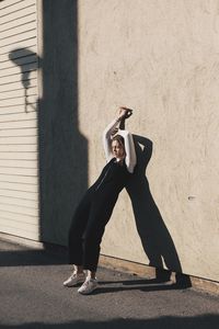 Full length of young woman leaning on wall