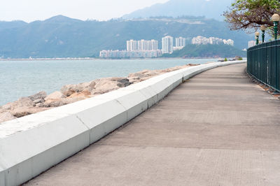 Scenic view of sea by buildings against sky