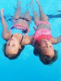 High angle view of two girls swimming in pool