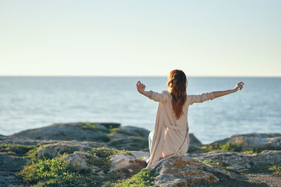 Rear view of woman in sea against clear sky