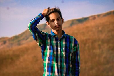 Portrait of young man standing on field