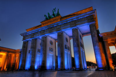 Low angle view of illuminated building against sky at night