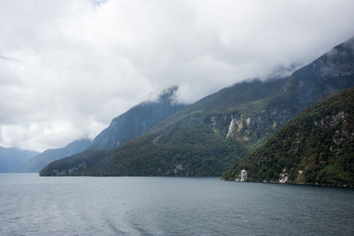 Scenic view of mountains and sea against cloudy sky