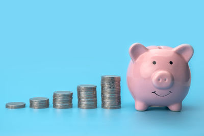 High angle view of coin stack against blue background