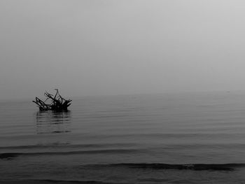 Fishing boat in sea against clear sky
