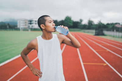 Portrait of young woman exercising on field