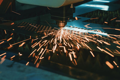 Machine for laser cutting of metal. laser head cuts the sheet with a beam, sparks scatter 