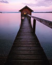 Pier over sea against sky at sunset