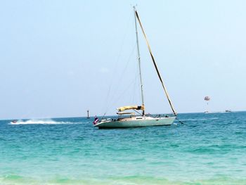 Sailboat sailing on sea against sky