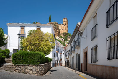 Street amidst buildings against clear sky