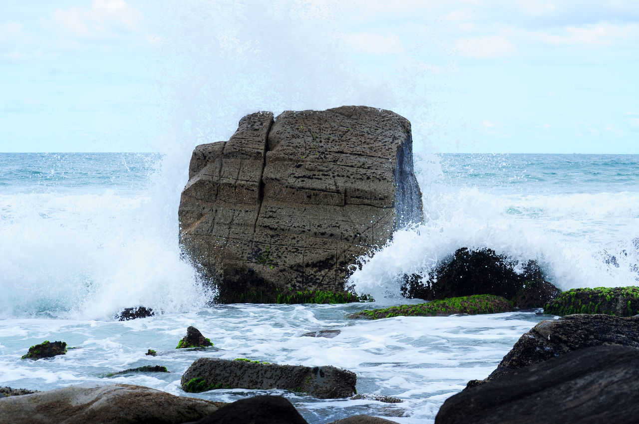 SCENIC VIEW OF SEA WAVES SPLASHING ON ROCKS