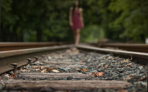 Close-up of railroad track, female in background. 