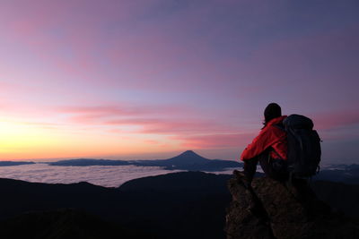 Rear view of woman sitting on cliff at japanese alps